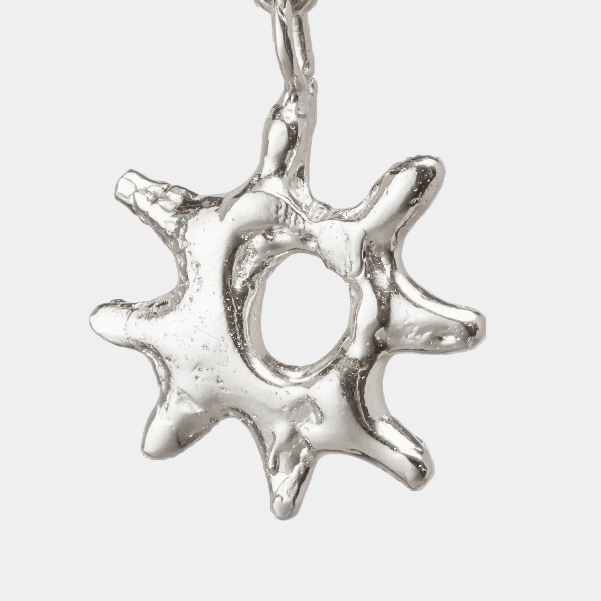 Silver star-shaped pendant on a white background