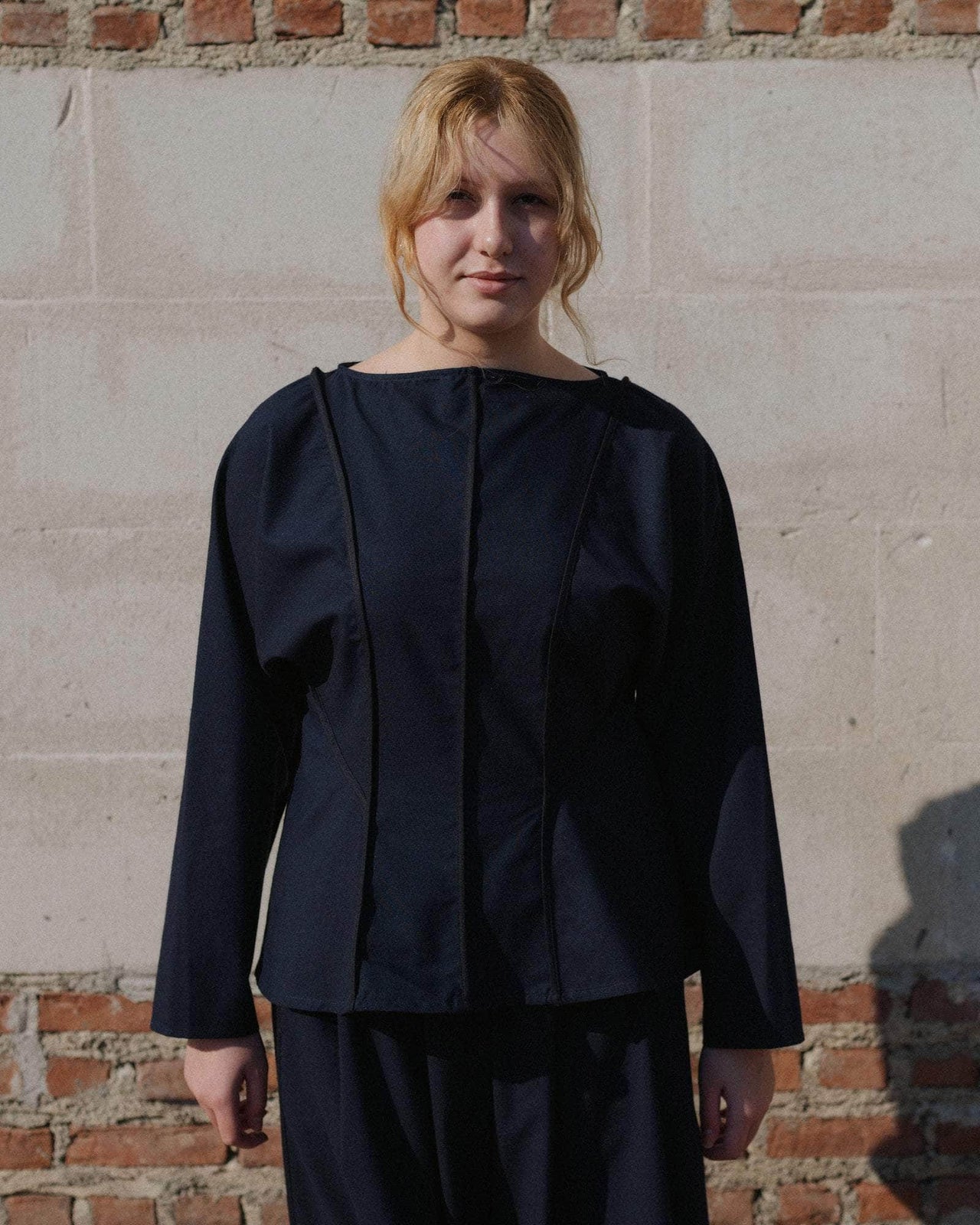 Black long-sleeve top on a light gray background